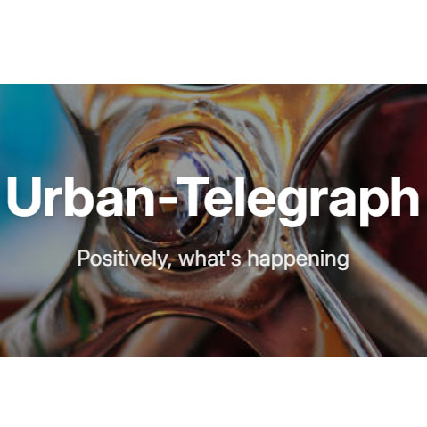 Close-up of metallic, shiny gears or machinery parts with the text Urban-Telegraph and Positively, whats happening displayed in bold white letters across the image.
